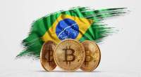 Bandeira do Brasil atrás de moedas físicas do Bitcoin