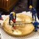 Miniaturas de homens em cima de moeda de Bitcoin gigante fazendo medição pela metade