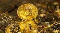 Moedas douradas de bitcoin sob a mesa