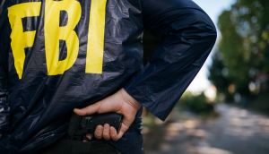 Agente do FBI retirando arma das costas