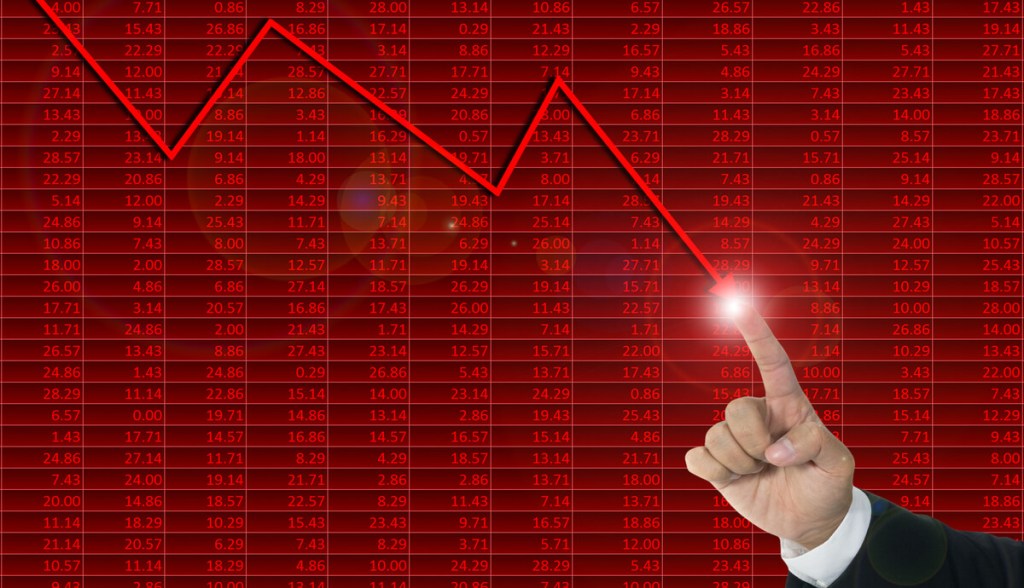 Homem toca tela vermelha com gráfico de baixa
