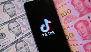 celular com logo do TikTok em cima de notas de dólares