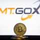 Moeda de Bitcoin à frente de logo da Mt. Gox