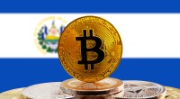 Moeda de Bitcoin à frente de bandeira de El Salvador