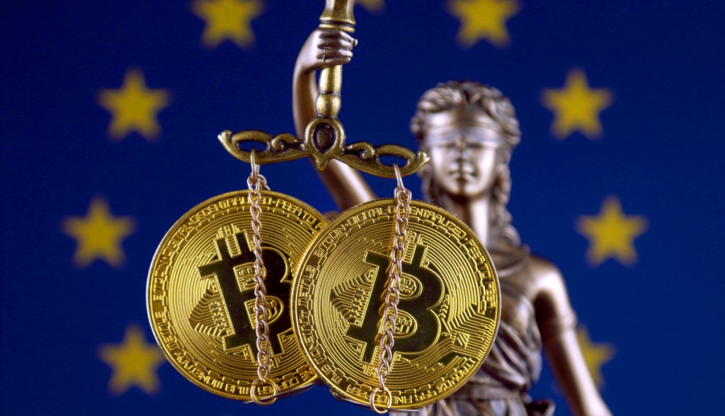 Estátua da justiça com moedas de Bitcoin - regulação europeia