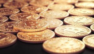 Moedas Douradas de Bitcoin em cima de uma superfície preta