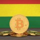 Moeda de Bitcoin à frente de bandeira da Bolívia