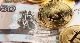 moeda de bitcoin em cima de nota de 50 rublos