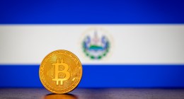 Moeda de Bitcoin à frente de bandeira de El Salvador