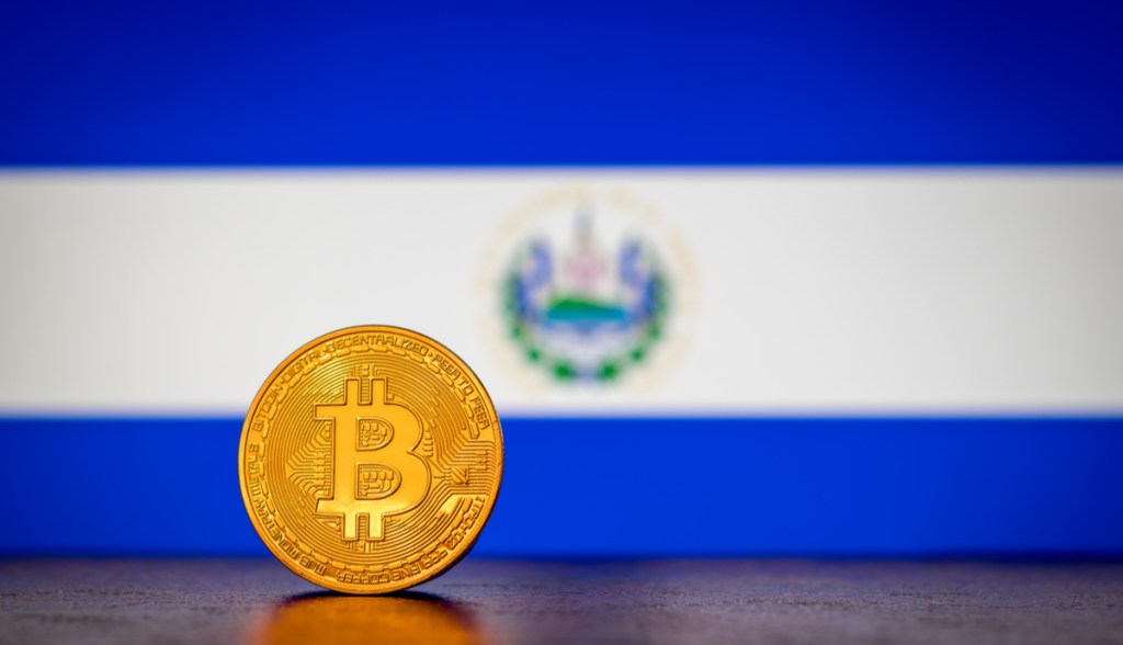 Moeda de Bitcoin à frente de bandeira de El Salvador