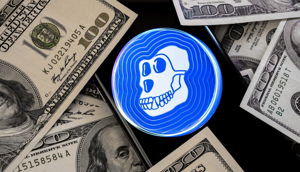 Moeda apecoin junto com maços de dólar