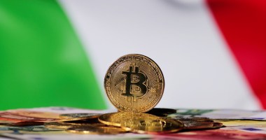 moeda de Bitcoin à frente de bandeira da Itália