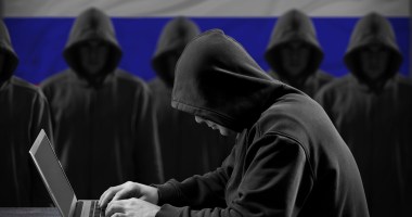 Homem hacker com capuz preto mexendo no computador para cibercrime .jpg