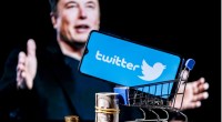 Elon Musk é retratado ao fundo. No primeiro plano, um carrinho de compras contendo o logo do Twitter.