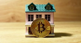 Modelo de casa com uma moeda de bitcoin