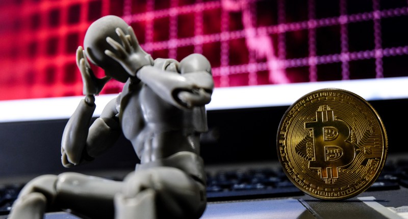 um robô triste sentado na frente do bitcoin em crise