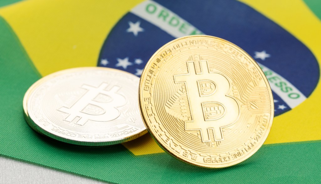 Moedas de Bitocin sobre bandeira do Brasil