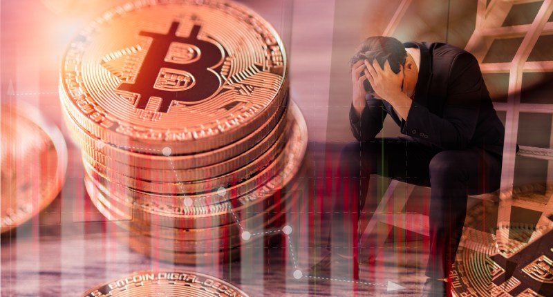Homem em desespero com moeda de bitcoin