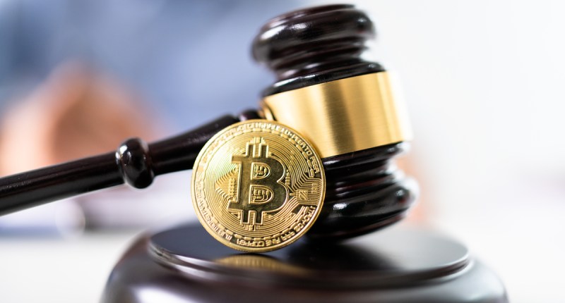Martelo que simboliza uma decisão judicial e um moeda de Bitcoin