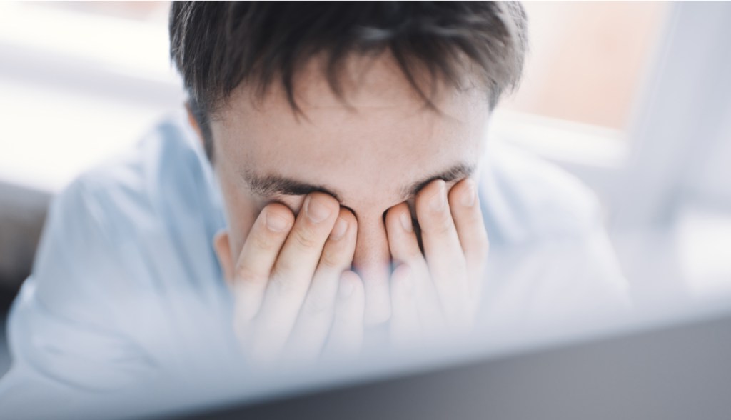 Jovem empresário cansado esfregando o olho