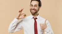 Homem de gravata segura contente uma moeda de bitcoin