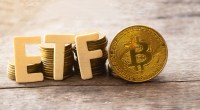 Letras que formam a sigla ETF próximas a uma moeda dourada de Bitcoin (BTC)
