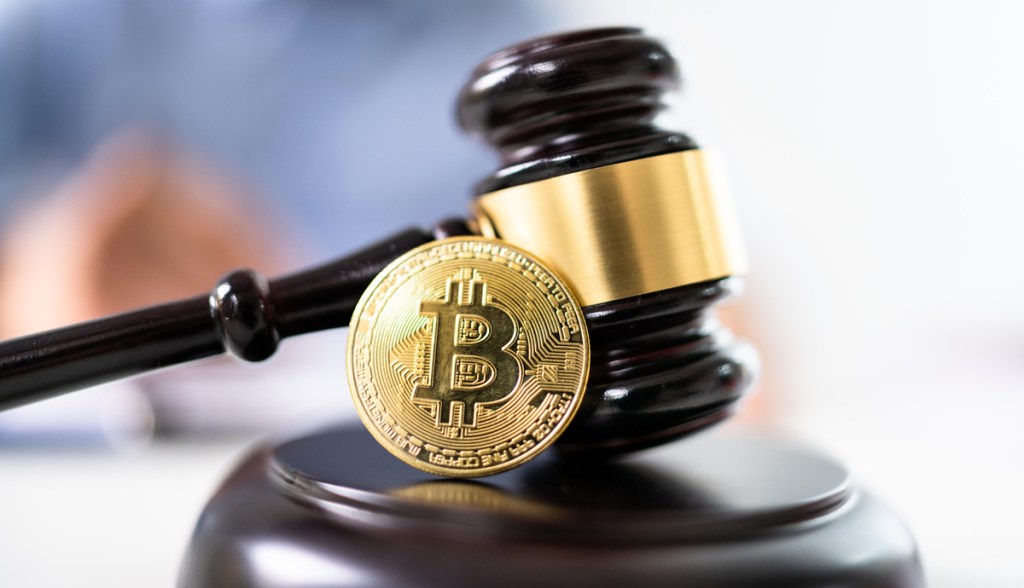 Martelo de juiz usado em tribunal e na corte com advogados na frente de uma moeda de bitcoin