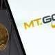 moeda de bitcoin ao lado de celular com logo da mt gox