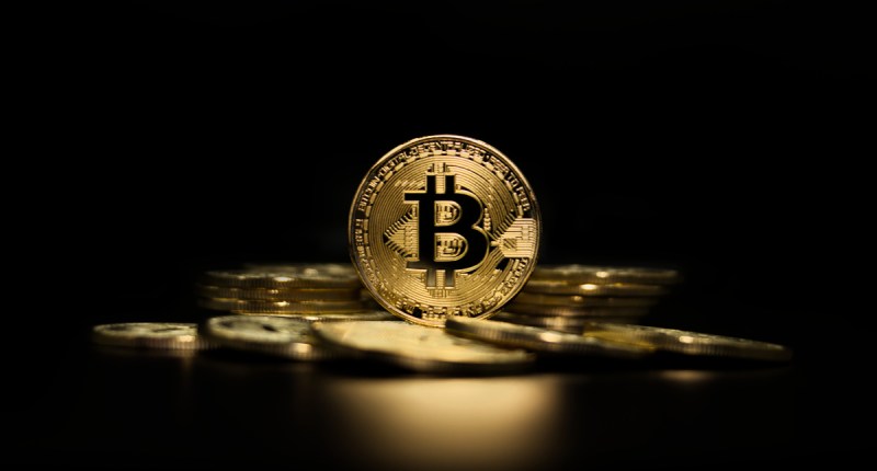 moeda de bitcoin exposta à frente de fundo escuro