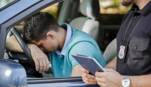 Policial olha homem desolado no interior de um carro
