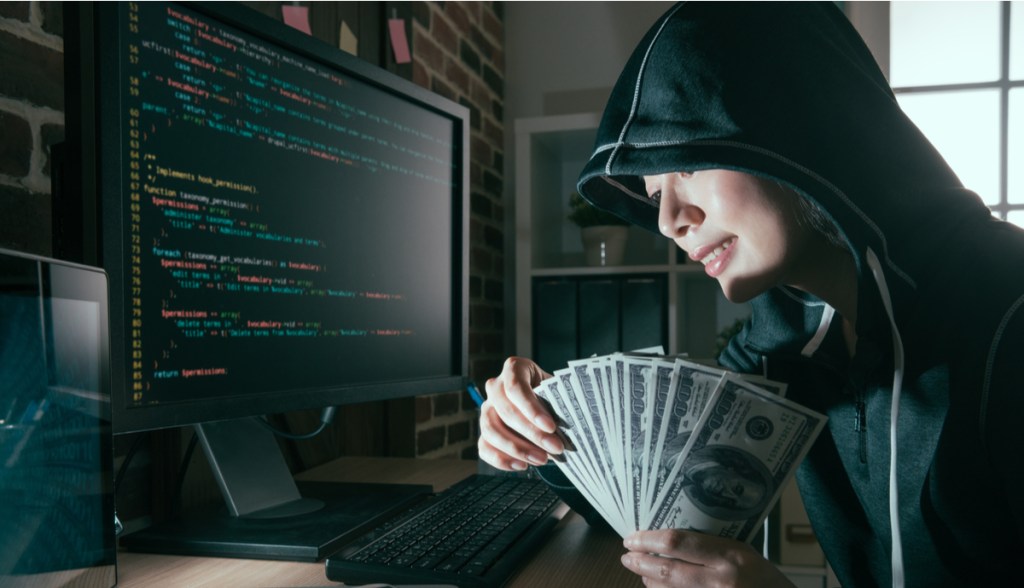 Hacker com dinheiro nas mãos