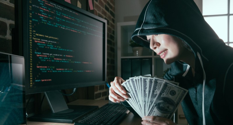 Hacker com dinheiro nas mãos