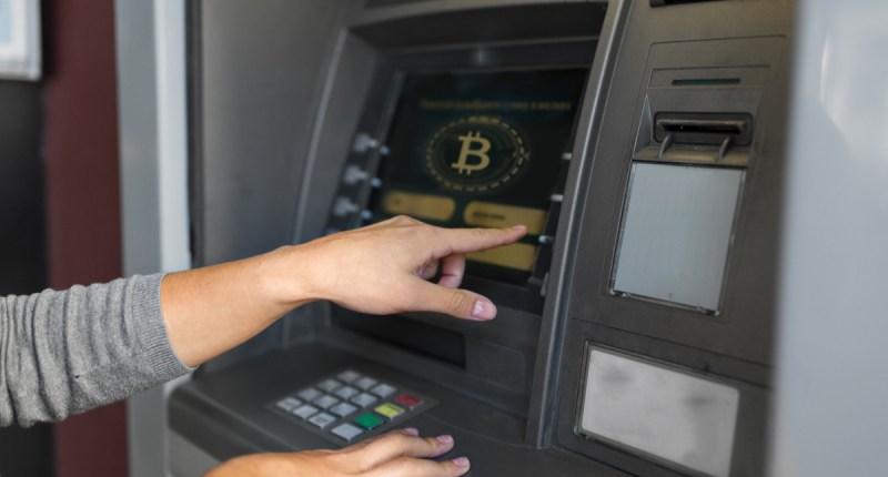 Indivíduo faz saque em ATM de Bitcoin