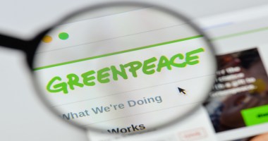 Lupa à frente de tela de computador mostra logo da Greenpeace