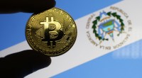 Pessoa segura moeda de bitcoin à frente de bandeira de El Salvador
