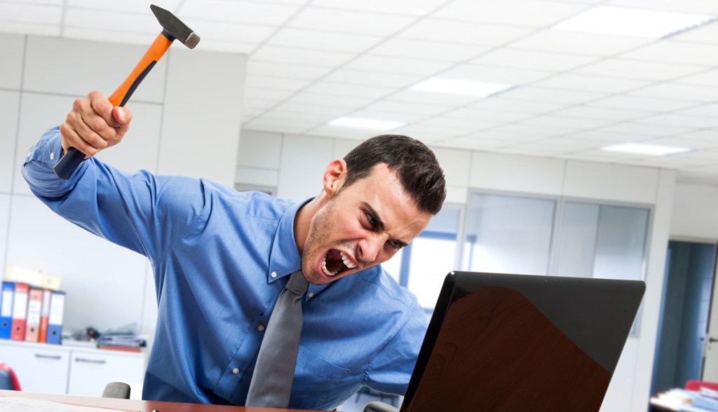 Homem martelando o computador