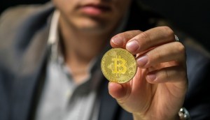 Homem segurando bitcoin