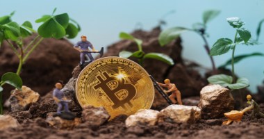 miniaturas de pessoas minerando bitcoin em meio a pedras e folhagens