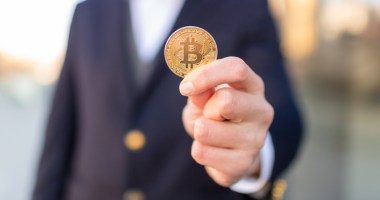 Moeda de bitcoin na mão de uma pessoa