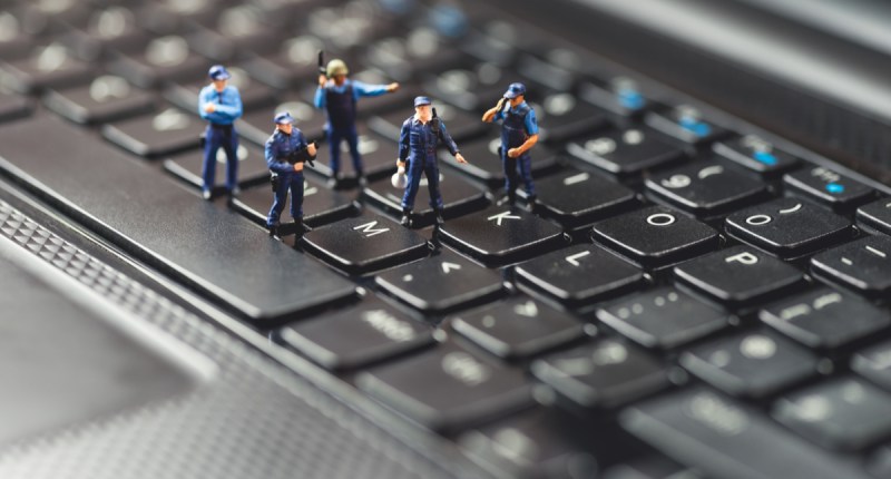 Bonequinhos de policiais em cima de um teclado