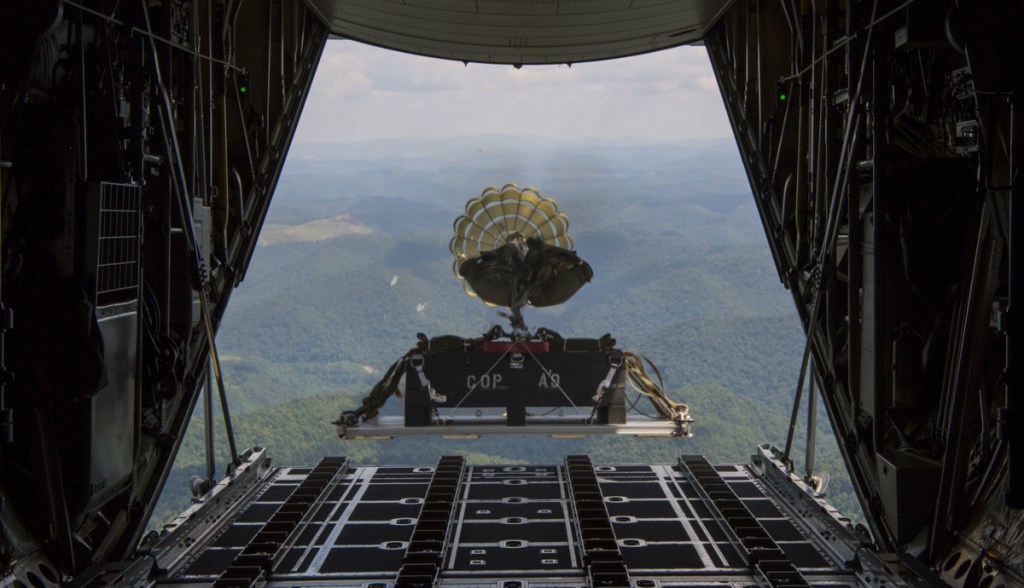 Caixa saindo de paraquedas de avião