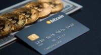 Moedas de bitcoin e cartão com o tema em cima de dólares sob mesa escura