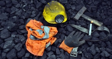 roupas de minerador sobre monte de carvão