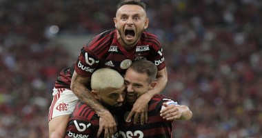Trẽs jogadores do Flamengo comemoram abraçados em campo