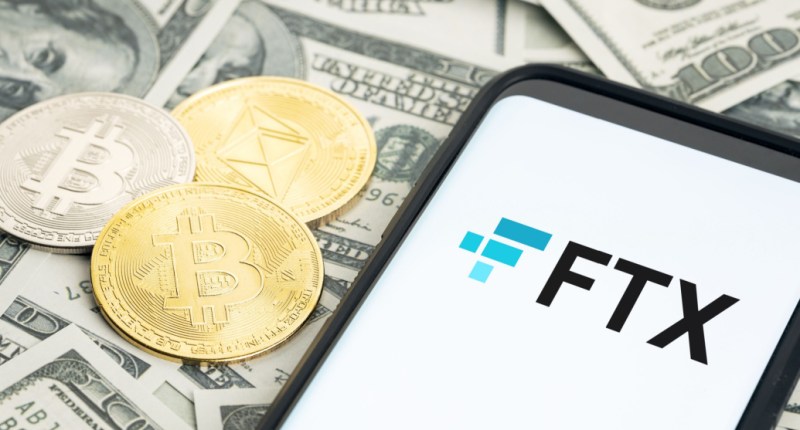 criptomoedas e celular com logo da FTX sobre notas de dinheiro