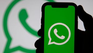 mão segura celular com logo do whatsapp