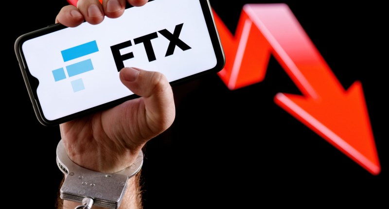 Homem algemado segura celular com logo da FTX