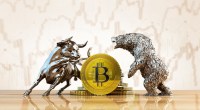 Moeda de bitcoin entre as estátuas de um touro e de um urso
