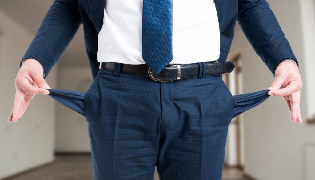 Homem mostra os bolsos vazios