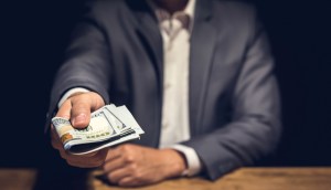 Homem oferecendo maço de dinheiro
